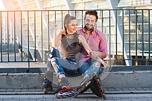 Smiling young couple on rollerblades.