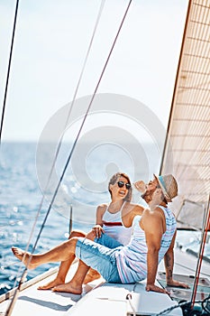 Smiling couple spending time together and relaxing on yacht