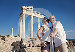 Smiling young couple take a selfie photo on antique ruins