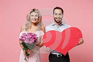 Smiling young couple two guy girl in party outfit celebrating posing isolated on pink background. Valentine`s Day Women