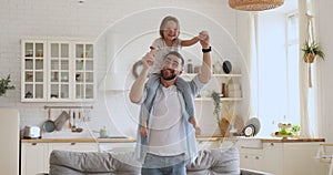 Smiling young daddy carrying excited little daughter, dancing together.