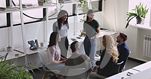 Smiling young diverse speakers involving teammates in teambuilding activity.