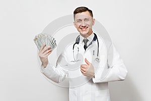 Smiling young doctor man isolated on white background. Male doctor in medical uniform showing thumbs up, holding bundle
