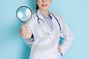 Smiling young doctor standing in blue background