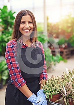 Smiling young employee in a flower nursery
