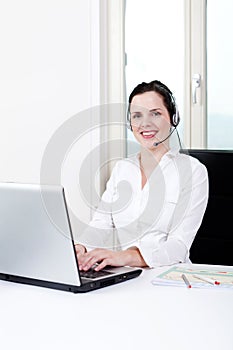 Smiling young female callcenter agent with headset