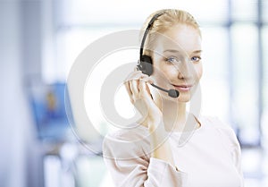 Smiling young female customer service agent with headset