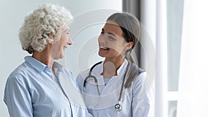 Smiling young female nurse assisting happy grandma helping in rehabilitation