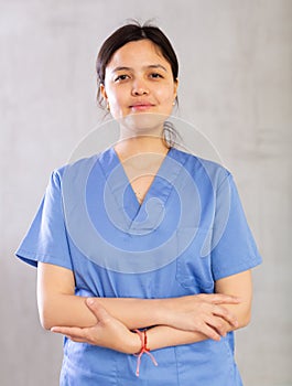 Smiling young female professional doctor in blue scrub