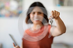 Smiling Young Female Real Estate Agent Holding Clipboard And Showing Home Keys