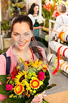 Smiling young florist woman colorful bouquet shop