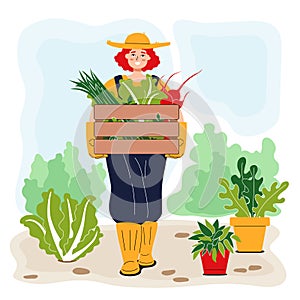 Smiling young gardener carrying a box of vegetables. Redhead girl in a hat holding chinese cabbage, onion and beetroot