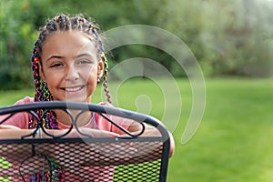Smiling young girl with colorful braids in her hair