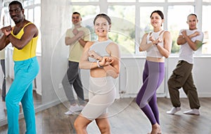 Smiling young girl enjoying vigorous dance at group class