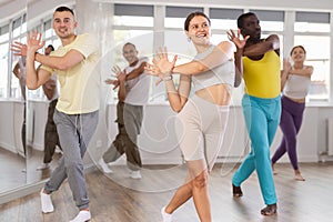 Smiling young girl enjoying vigorous dance at group class