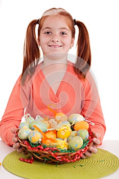 Smiling young girl holding easter eggs basket