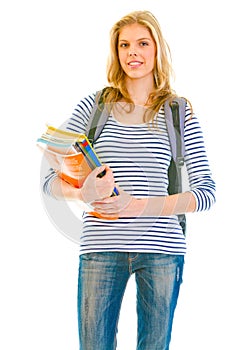 Smiling young girl holding schoolbooks in hands
