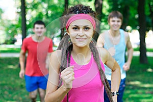 Smiling young girl jogging outdoors