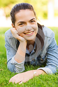 Smiling young girl lying on grass