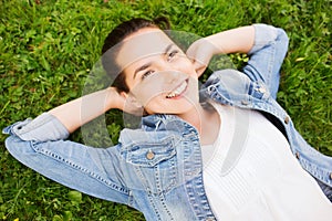 Smiling young girl lying on grass