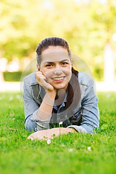 Smiling young girl lying on grass