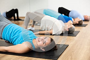 Smiling young girl performing glute bridge during workout