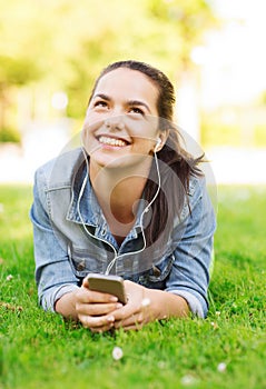 Smiling young girl with smartphone and earphones