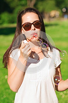 Smiling young girl with soap bubbles in park