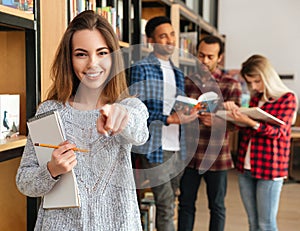 Smiling young girl student holding textbook