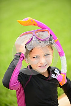 Smiling young girl with swimming goggles and snorkel