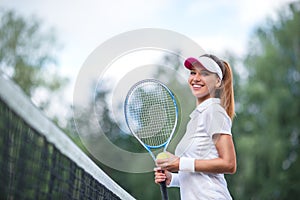 Smiling young girl with a tennis racket