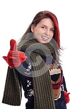 Smiling young girl in warm winter clothes giving thumbs up