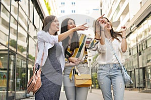 Smiling young girls walking on street with shopping bags. Girl s