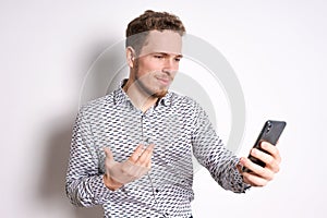 Smiling young handsome caucasian man using a smartphone to contact family