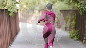 Smiling young happy millennial girl looking at camera makes hand gesture, invites you to do sports together. Mixed race