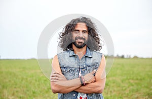 Smiling young hippie man on green field