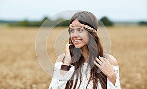 Smiling young hippie woman on cereal field