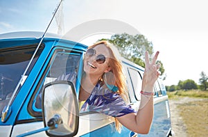 Smiling young hippie woman driving minivan car