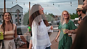 Smiling young hipster people dancing enjoy music audio sound at roof summer party event discotheque