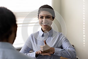 Smiling young Indian woman who is deaf using sign language