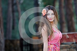Smiling young lady with attached flower in hair
