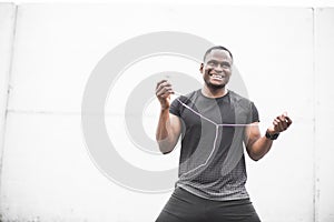 Smiling Young male jogger athlete training and doing workout outdoors in city. a black man resting after a workout and