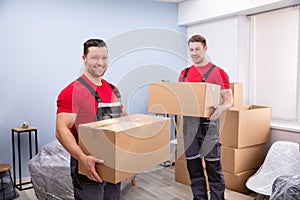 Smiling Young Male Relocation Worker Carrying Cardboard Boxes