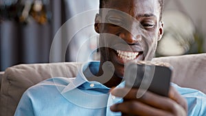 Smiling young male talking with friend using smartphone video conference calling in virtual webcam
