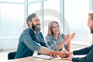 Smiling young man answering employers ` questions during the interview