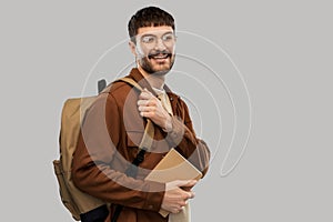 Smiling young man with backpack and diary