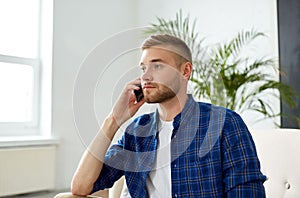 Smiling young man calling on smartphone at office