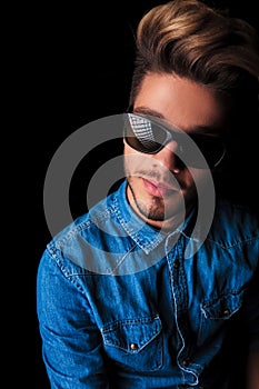 Smiling young man in denim shirt wearing sunglasses