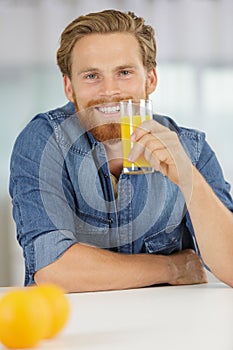 Smiling young man drinking orange juice