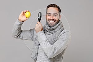 Smiling young man in gray sweater scarf isolated on grey background studio portrait. Healthy lifestyle ill sick disease